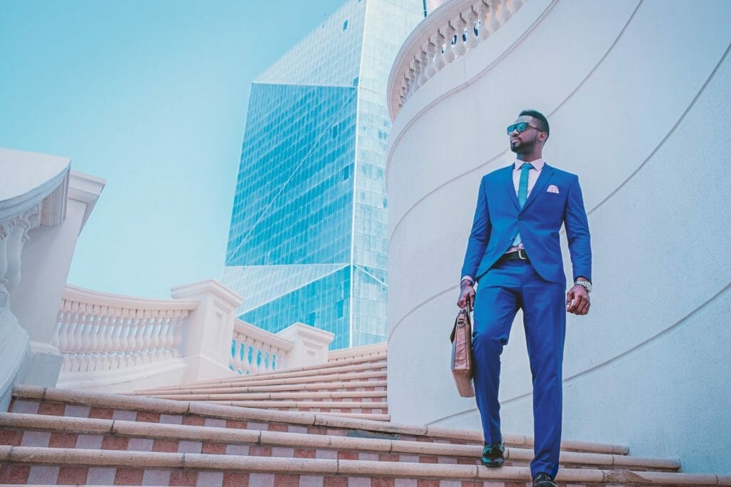 Signs of success man in blue suit walking down steps outside