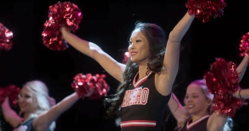 A cheerleader with hands out during a routine