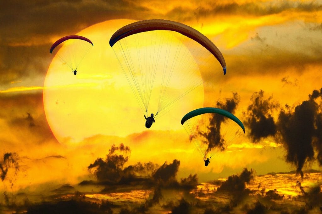 Seizing opportunity. Paragliders over a sunset